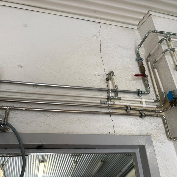 Einangraðar útilagnir festar meðfram húsvegg og inn í bygginguna.